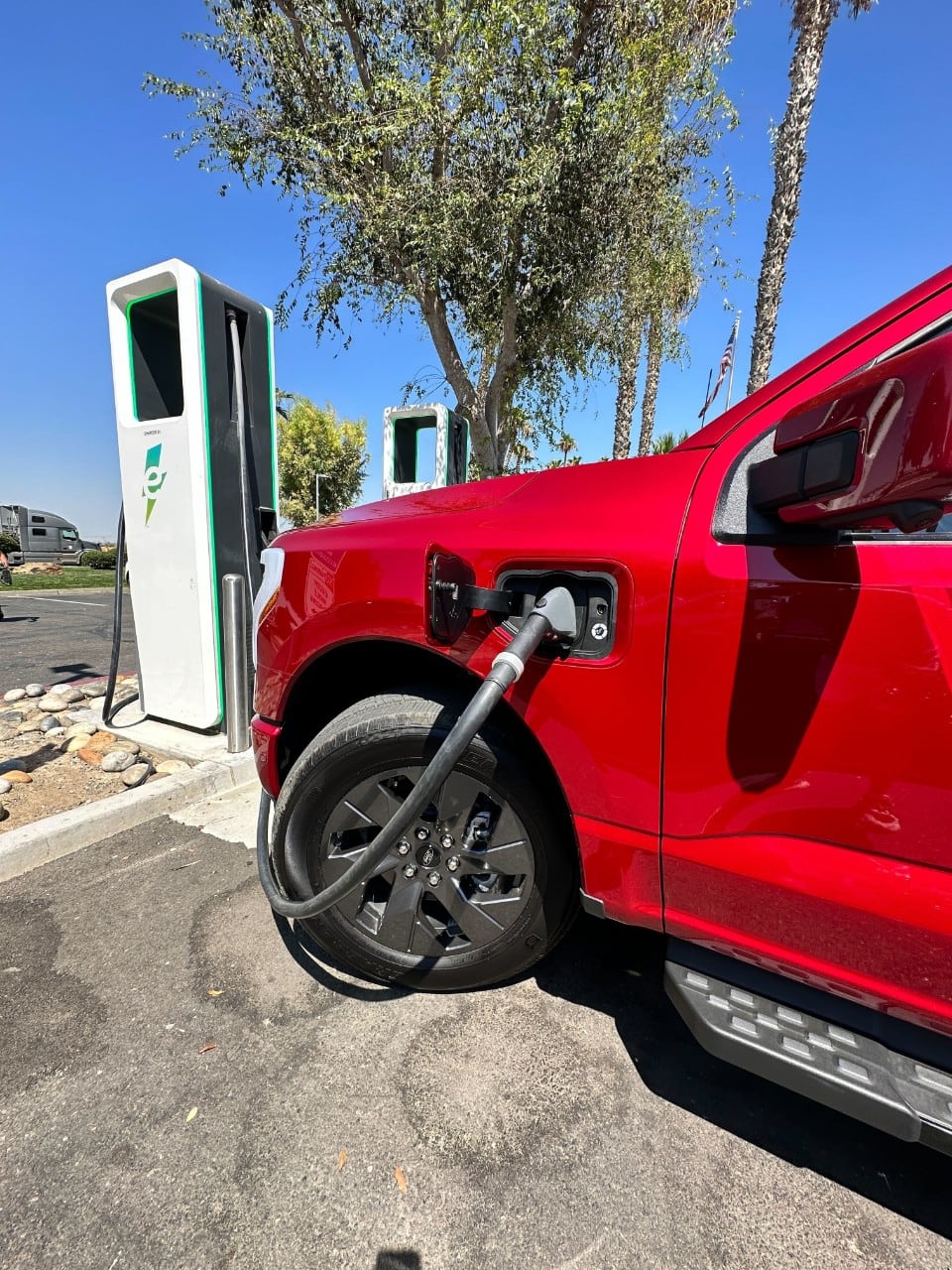 A red electric vehicle is plugged into a charger.